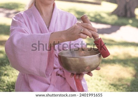 Woman playing on a tibetian singing bowl, Nepal  copper sound bowl at spa salon. Young girl doing therapy meditation singing bowls. take out stress, make relax and harmony. 