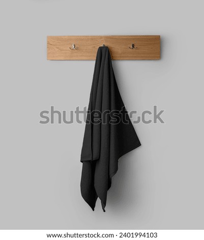 Mockup of a terry black towel on a wooden hanger, hanging toweling for design, branding, presentation. Home decor for wiping. Towelette template isolated on background. Product photography.