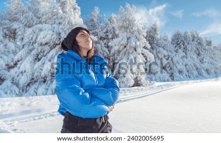 Relaxed woman breathing fresh air in a snowy winter mountain . Winter time Royalty-Free Stock Photo #2402005695