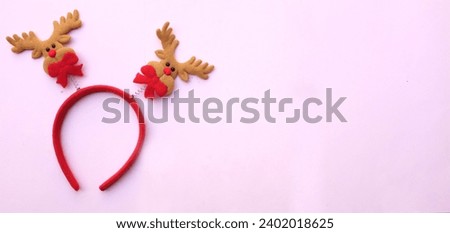 cute Christmas headbands with christmas reindeer horns isolate on a pink pastel backdrop. concept of joyful Christmas party,New year is coming soon, festive season decoration with Christmas elements
