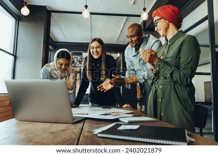 Successful interior designers applauding cheerfully during an online meeting. Group of multicultural businesspeople celebrating their achievement during a video conference. Royalty-Free Stock Photo #2402021879