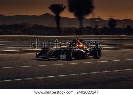 Formula 1 car go fast at the raceway during sunset Royalty-Free Stock Photo #2402029247