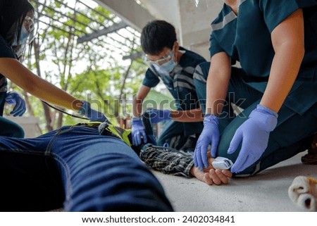 Rescuers are using equipment to check the body's pulse of worker at construction sites while unconscious and lying on the floor. Reading heartbeat with an oximeter.