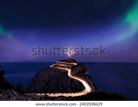 Milky way rising over an illuminated road with light trails at the Far de Formentor lighthouse on the island of Mallorca, Spain Royalty-Free Stock Photo #2402038629