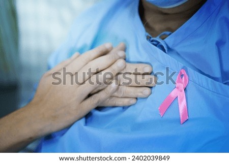 Breast cancer, pink ribbon at Asian senior lady patient for supporting awareness.