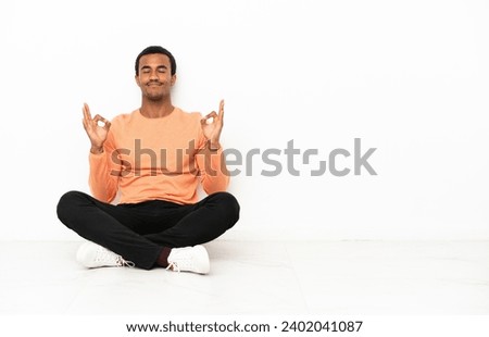 African American man sitting on the floor over isolated copyspace background in zen pose