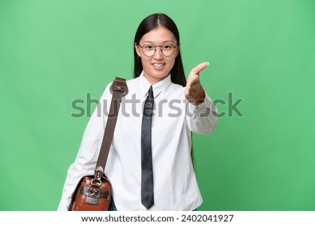 Young Asian business woman over isolated background shaking hands for closing a good deal
