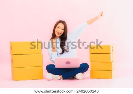Portrait beautiful young asian woman use computer laptop on pink color isolated background