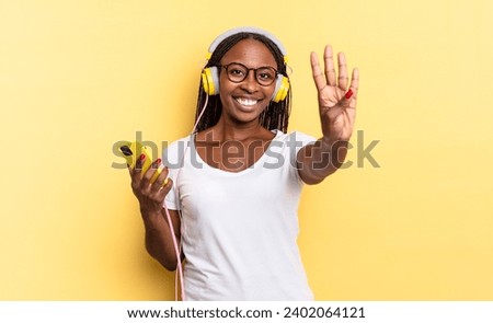 smiling and looking friendly, showing number four or fourth with hand forward, counting down and listening music