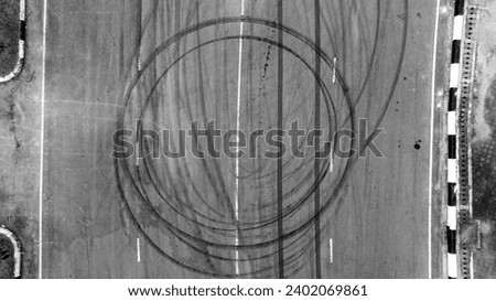 Aerial top view car tire marks burnout, Tire marks on the asphalt road, Tire mark on race track texture and background. Royalty-Free Stock Photo #2402069861