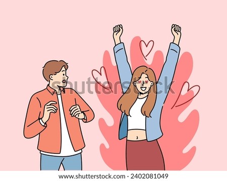 Excited woman is in love with man who is scared because of excessive passion from fan. Guy looks excitedly at girlfriend feeling great passion and sympathy for boyfriend or fiance. Royalty-Free Stock Photo #2402081049