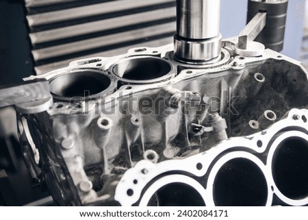 Three-cylinder engine repair on CNC machine, boring under the piston using machine with Computer Numerical Control.  Royalty-Free Stock Photo #2402084171