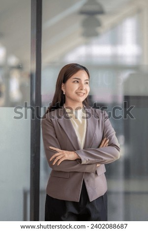 Half-body portrait of a business woman standing with arms crossed.