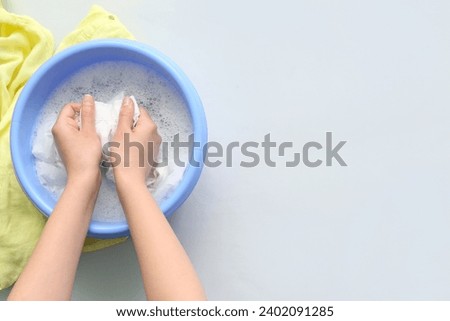 Woman washing clothes in plastic basin isolated on white background Royalty-Free Stock Photo #2402091285