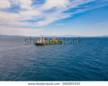Aerial shot of Bulk carrier ship anchored with pilot boat for crew change Royalty-Free Stock Photo #2402091925