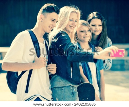 Teenagers taking pictures of themselves on smartphone