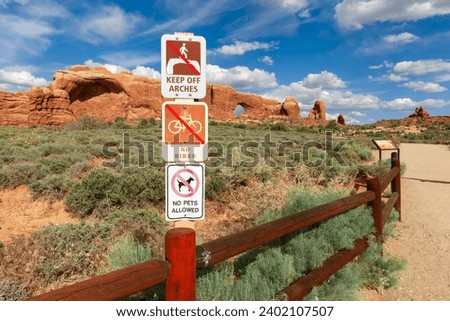Visitor Restriction Sign near The Windows Viewpoint and Trail in Arches National Park, Utah, United States. Keep off arches, No bikes, and No pets signs. Royalty-Free Stock Photo #2402107507