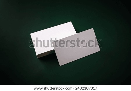 Photo of blank business cards on green background. For design presentations and portfolios.