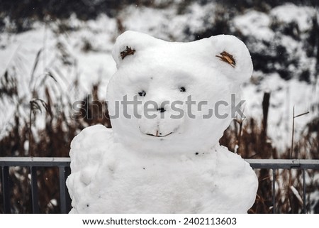 Frosty woodland companion: A snowman resembling a bear stands proudly amidst the snowy forest. Nature and winter whimsy unite in this enchanting scene.