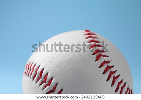 One baseball ball on light blue background, closeup