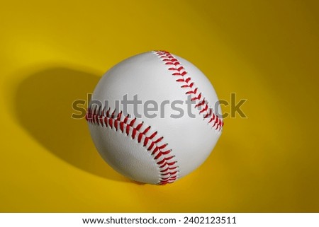 One baseball ball on yellow background, top view