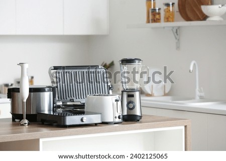 Set of modern appliances on wooden table in contemporary kitchen Royalty-Free Stock Photo #2402125065