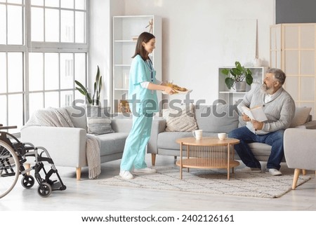 Nurse bringing breakfast to mature man at home