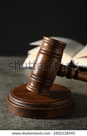 Law concept. Gavel and book on grey textured table, closeup
