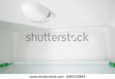 Ice and snow build up on the back wall of the refrigerator. Refrigerator failure, freon leak, temperature sensor defective. Royalty-Free Stock Photo #2402133895