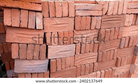 Pile of red bricks stacked neatly on a construction site for building a house.