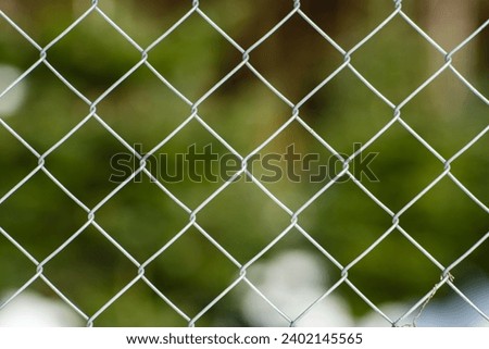 Chain link metal wire fence, close up shot, shallow depth of field, no people.