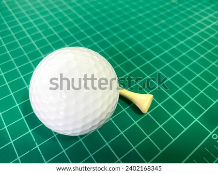 A picture of a golf ball placed on a green background. The material is rubber.