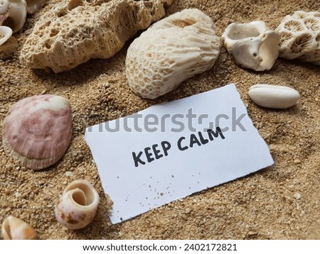 Keep calm written on beach sand background.