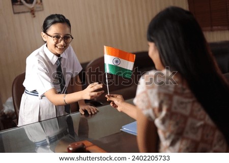 Happy proud Principal, teacher personally giving, offering Indian flag as a gift, award to a student for her promotion in school.