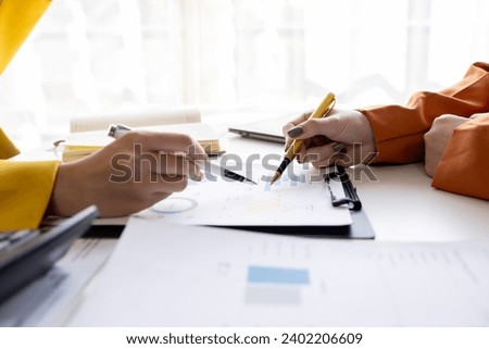 business women working on desk office with using a calculator to calculate the numbers tax, finance accountingresearch or financial strategy in company concept