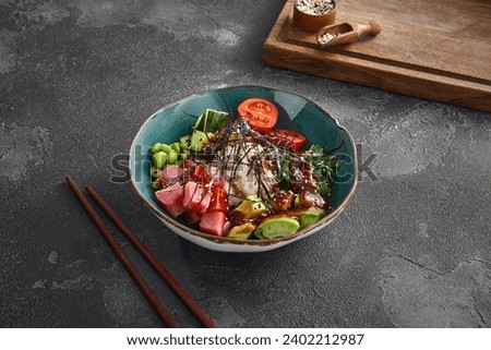 Fresh tuna poke bowl with ripe avocado, edamame beans, and rice, garnished with seaweed, in a ceramic bowl on a dark background. Ideal for healthy lifestyle concepts.