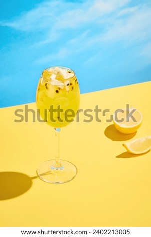 Tropical passion fruit spritz with sparkling wine, served on a sunny day with a clear blue sky.