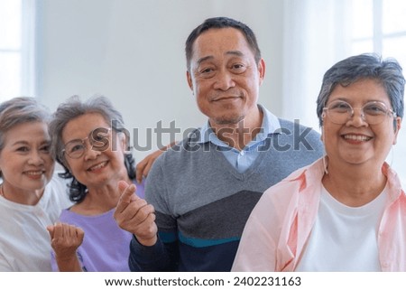 group of asian senior people standing with smart confidence. older people are listening and enjoy meeting focus group at living room. Joyful carefree retired senior friends enjoying relaxation.