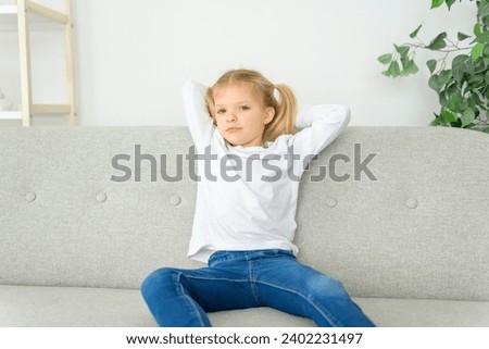 A Blond girl sit on sofa at home