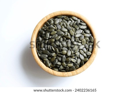 Natural green pumpkin seeds without shell isolated on white background. Healthy food concept. Overhead view. Copy space. Royalty-Free Stock Photo #2402236165