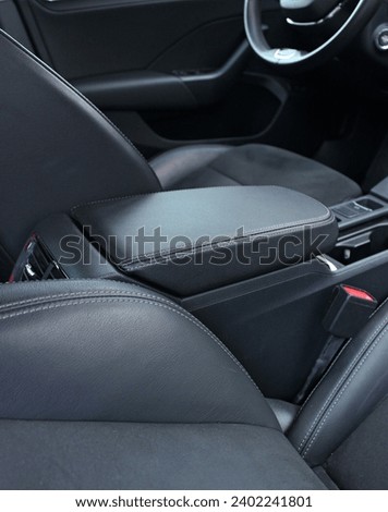 View from rear seats on a stitched leather trim of armrest between front seats inside the car 
 Royalty-Free Stock Photo #2402241801