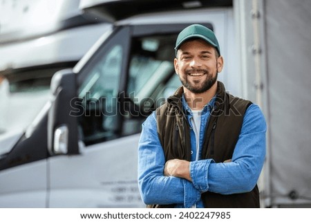 Happy confident male driver standing in front on his truck Royalty-Free Stock Photo #2402247985