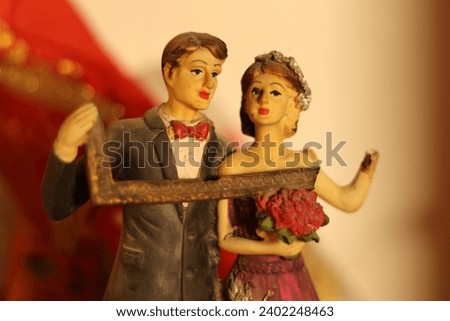 Closeup of Figure or sculpture of a broken bride and groom marriage holding photo frame, signifying divorce breakup