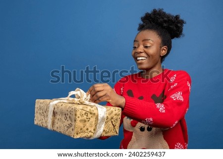 Happy young woman holding chirstmas gifts and looking excited
