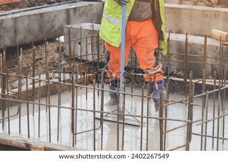 Concrete cast-in-place work. Builder level wet concrete. Concrete works on buildiiing construction site Royalty-Free Stock Photo #2402267549