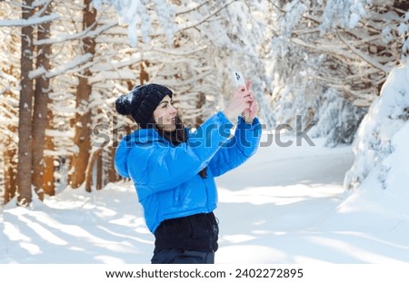 Young Woman taking pictures in the beautiful  Winter Mountain 