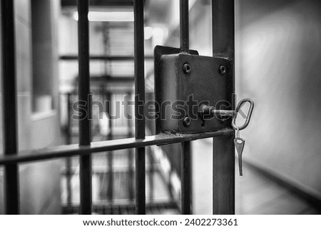 Grate with a key to a prison cell. Arrest. Royalty-Free Stock Photo #2402273361