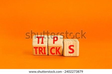 Tips and tricks symbol. Turned wooden cubes and changed the word tricks to tips. Beautiful orange table, orange background. Business, tips and tricks concept. Copy space.