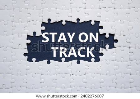 Stay on track symbol. Concept words Stay on track on white puzzle. Beautiful deep blue background. Business and Stay on track concept. Copy space.