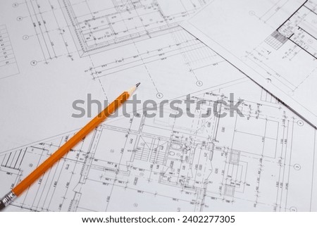 pencil and office tools for writing on the blueprint of construction industry. Place the rolls on a desk over blurred blueprint for construction industry background. construction industry concept.